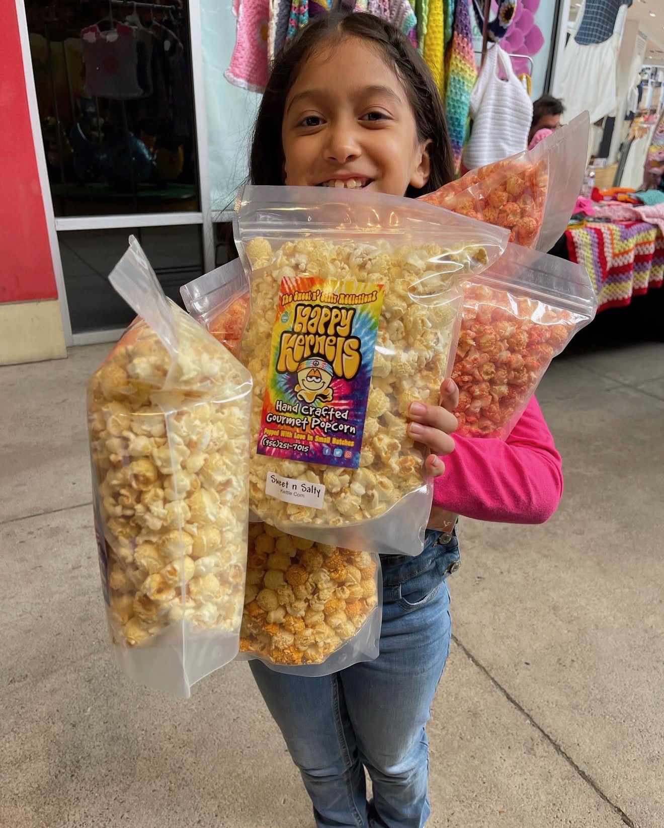 Student holding Happy Kernels fundraiser popcorn bags